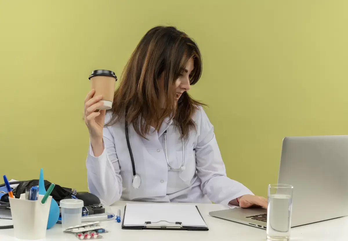 Médica trabalhando no computador do consultório, ilustrando a criação de sites para médicos